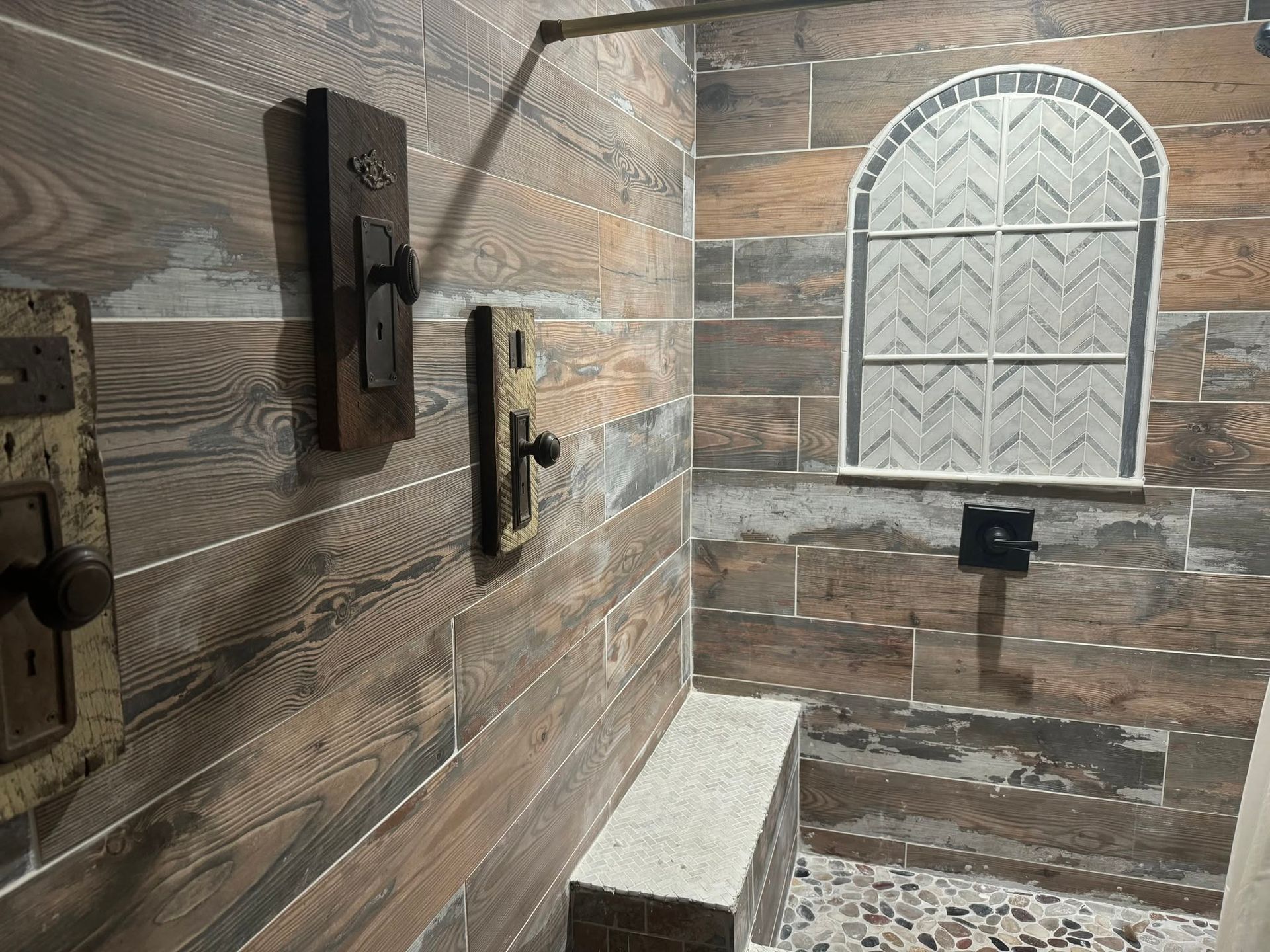 Wood-paneled accessible restroom with grab bars, toilet, and a frosted arched window.
