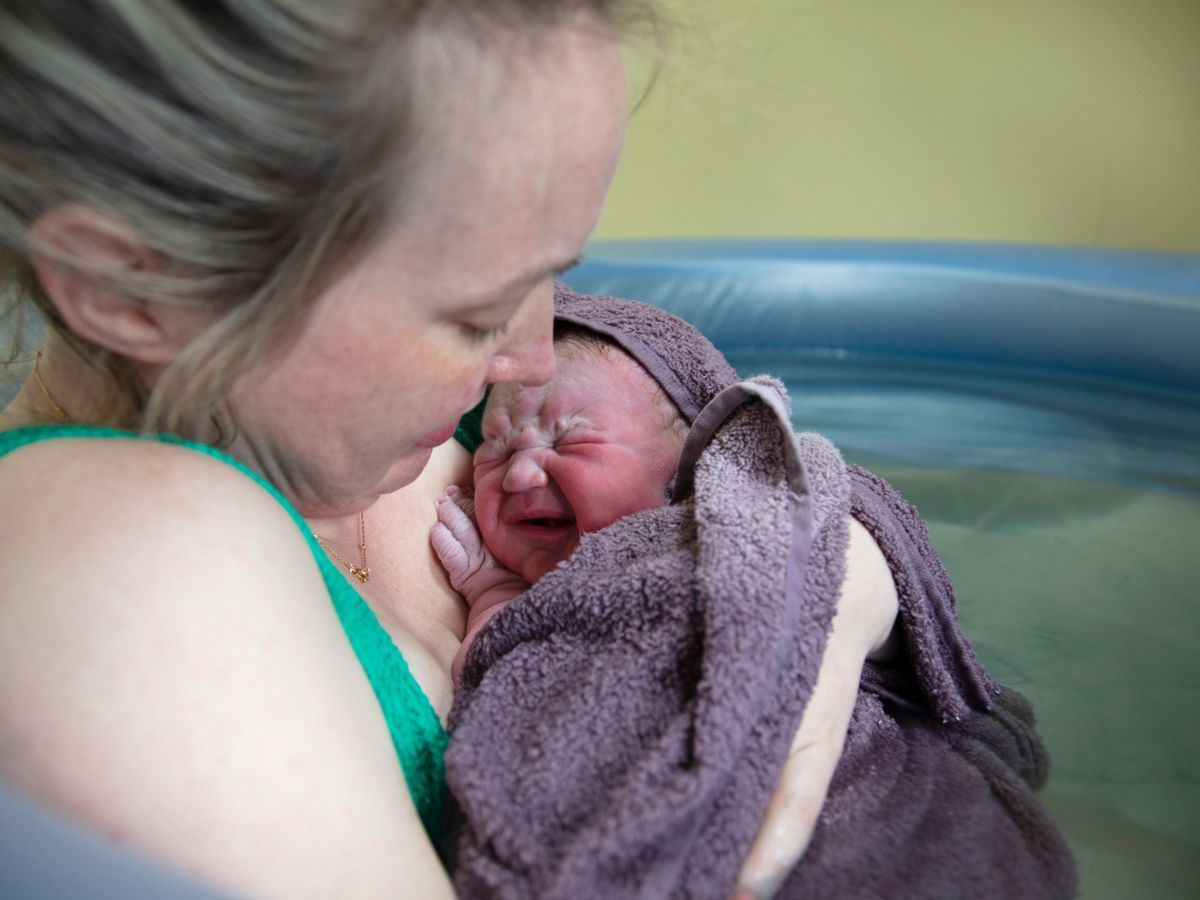 Mother holding baby in birthing pool