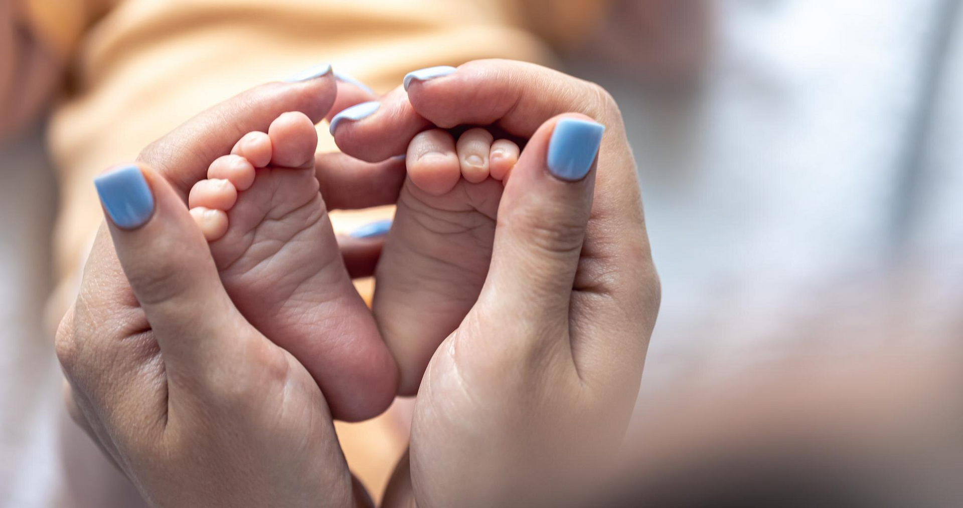 A mother holds her baby’s little feet after giving birth. 
