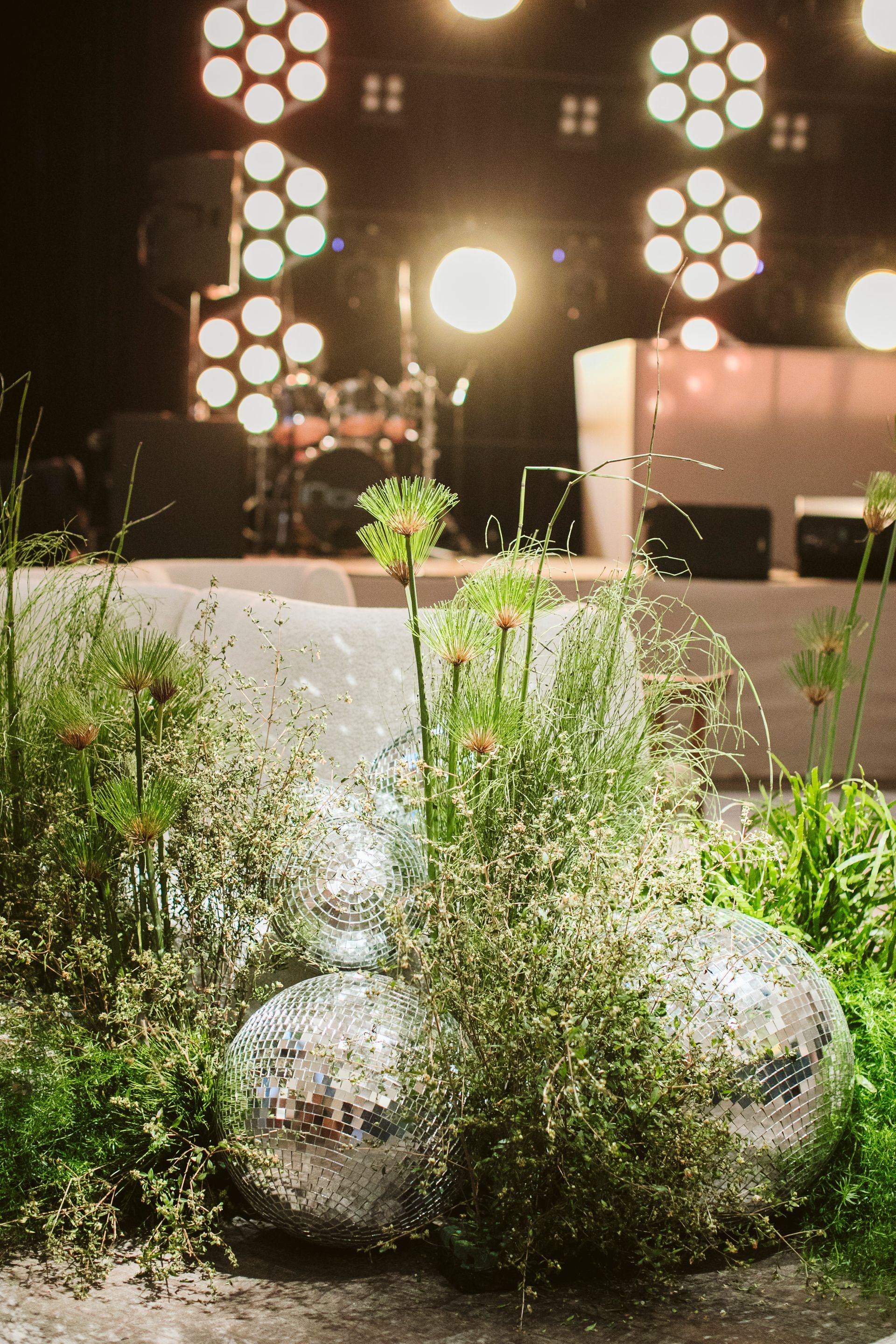 Uma bola de discoteca cercada por plantas e flores em um jardim.