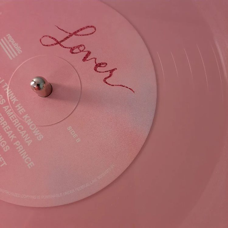 Um close de um disco rosa com a palavra amante escrita nele