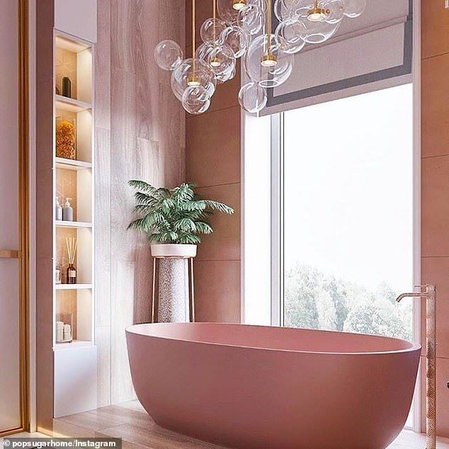 Um banheiro com uma banheira rosa e uma janela.