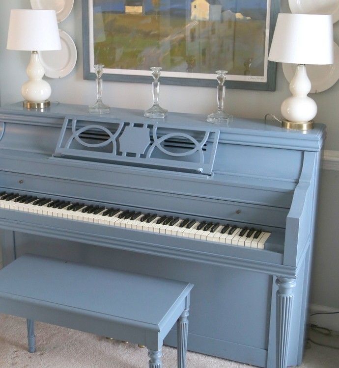 Um piano azul com um banco embaixo