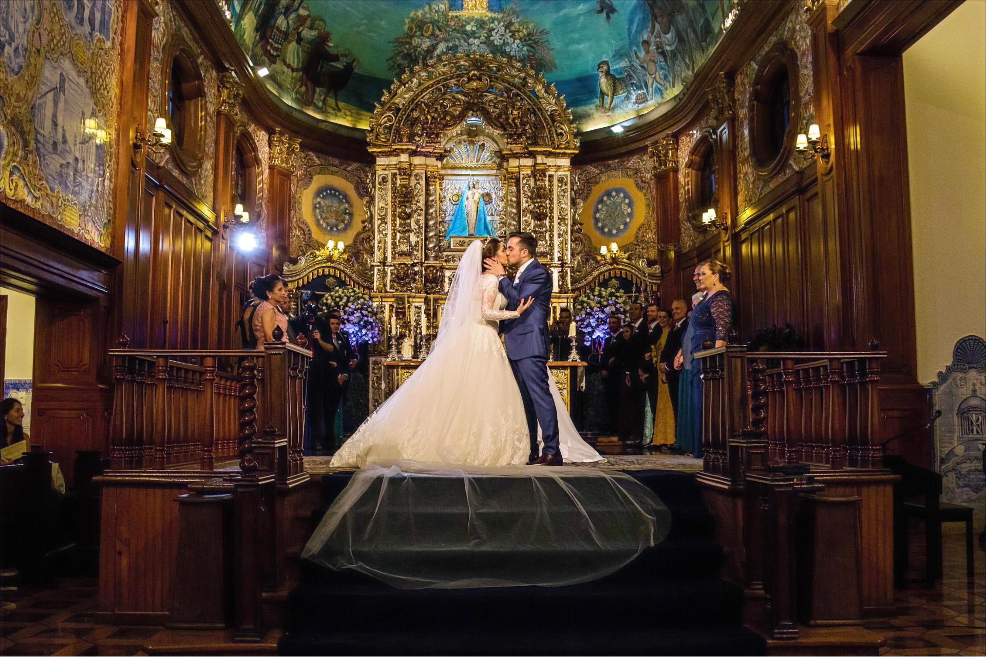 Uma noiva e um noivo se beijando em uma igreja durante a cerimônia de casamento.