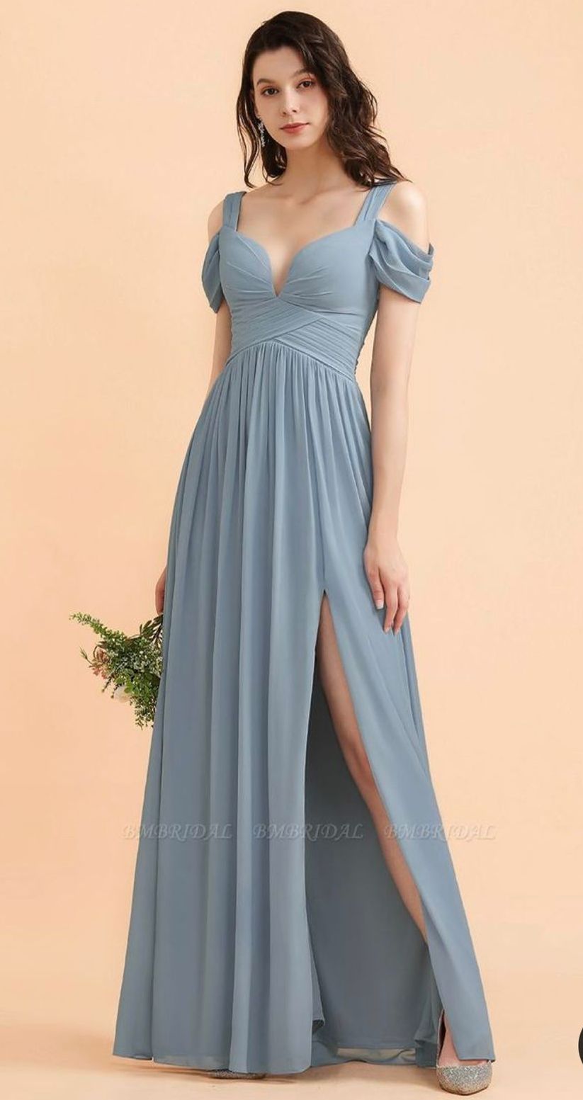 Uma mulher está usando um vestido azul de dama de honra e segurando um buquê de flores.