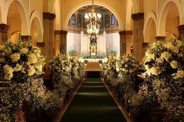 Uma igreja está decorada com flores e um tapete verde