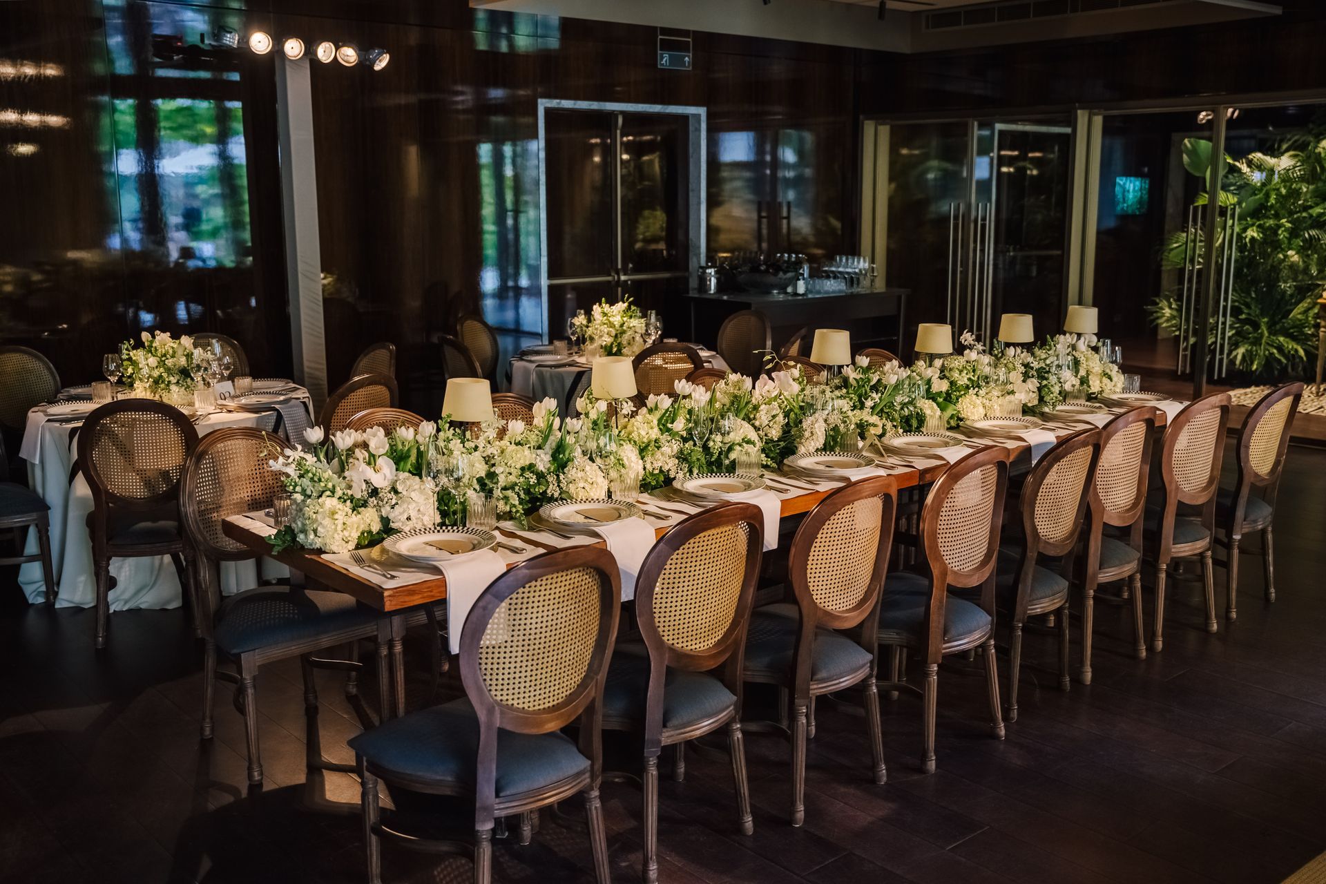 Uma mesa longa com muitas cadeiras e flores sobre ela