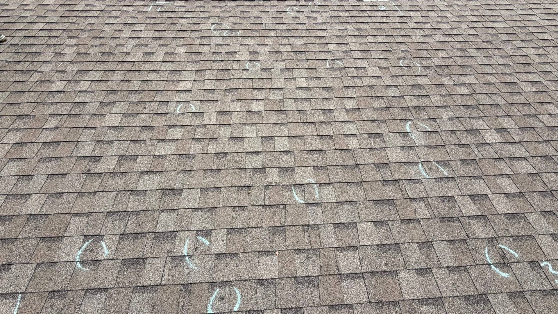 Brown shingle roof with light-colored chalk markings and weathered texture
