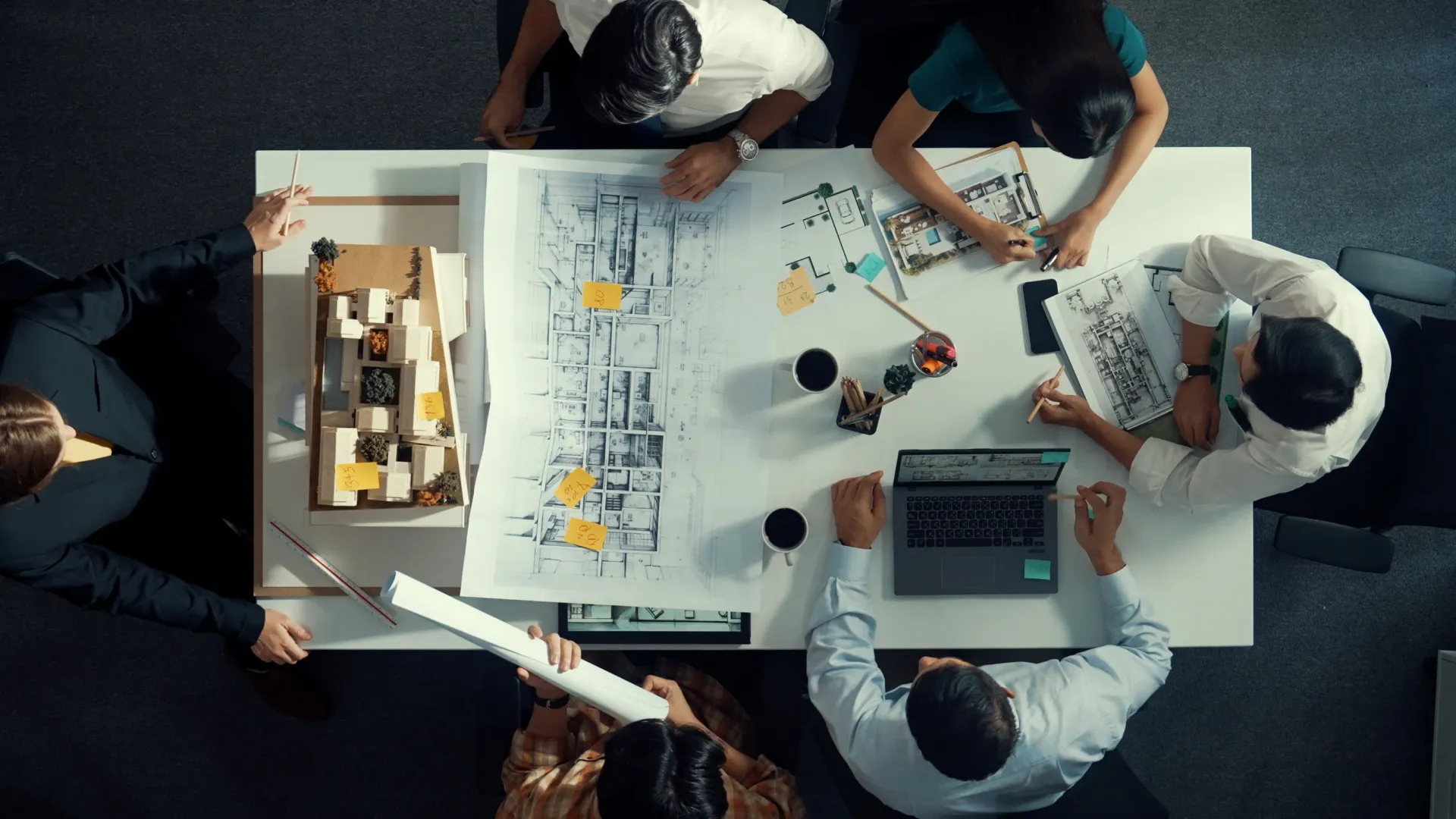 A group of people are sitting around a table working on a project.