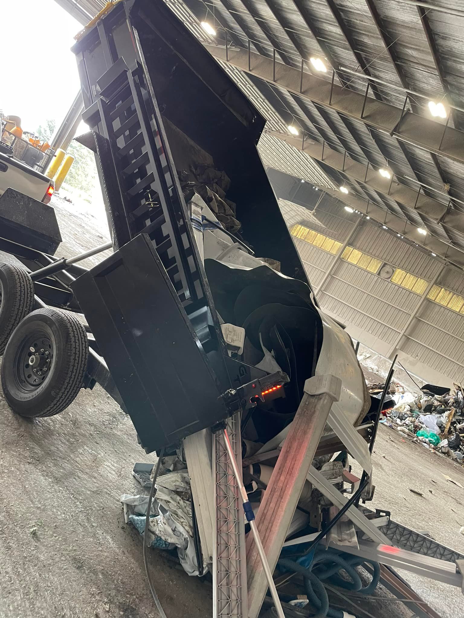 A dump truck is sitting upside down in a garage.
