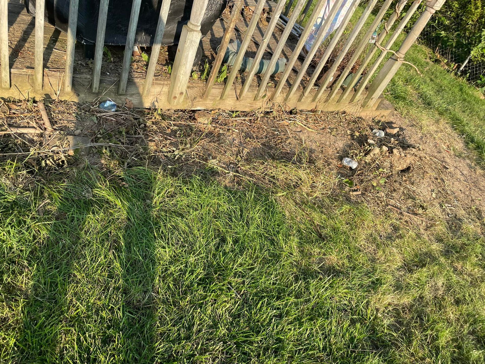 A wooden fence is sitting on top of a lush green field.