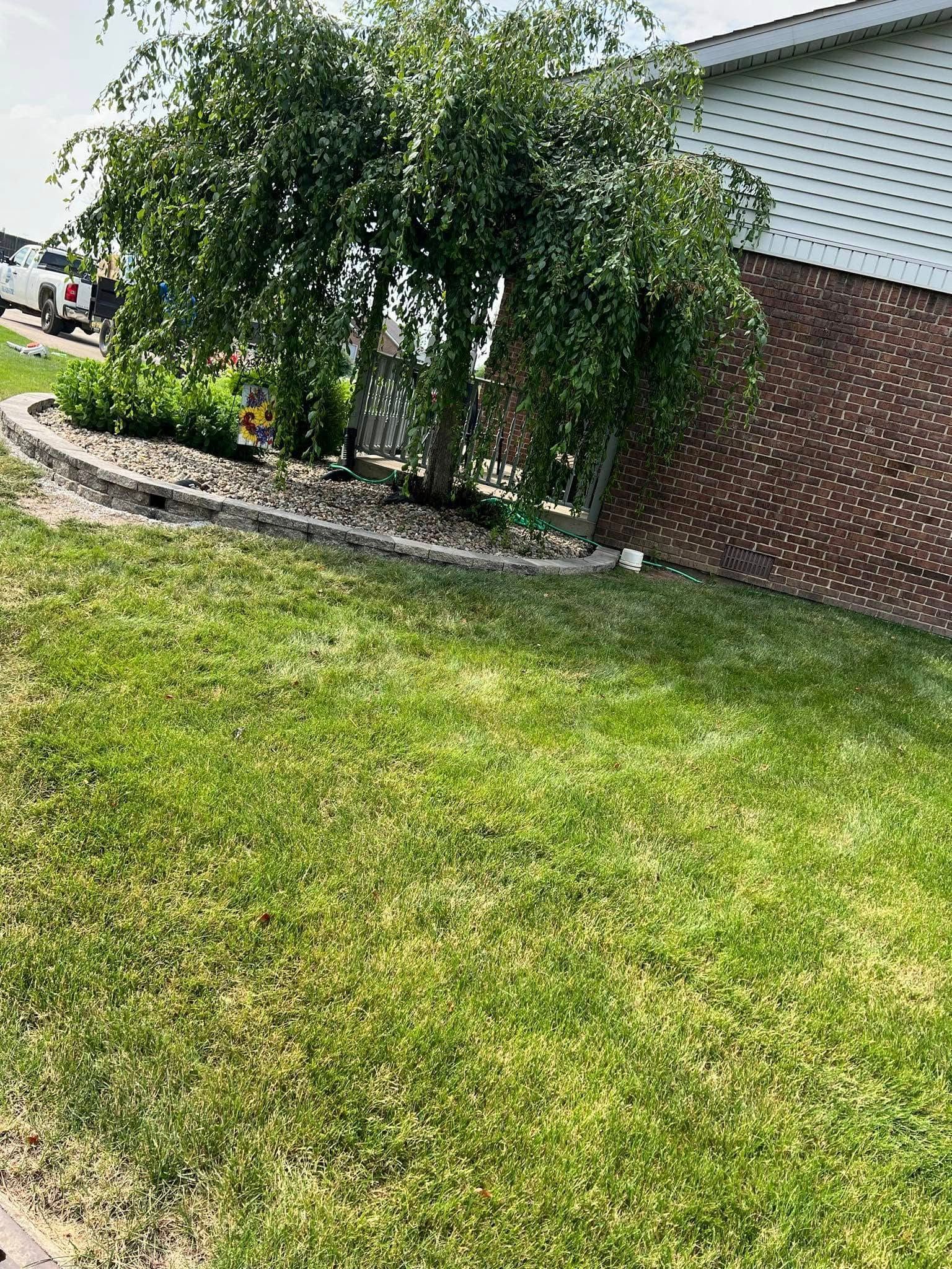 A lush green lawn in front of a brick house.