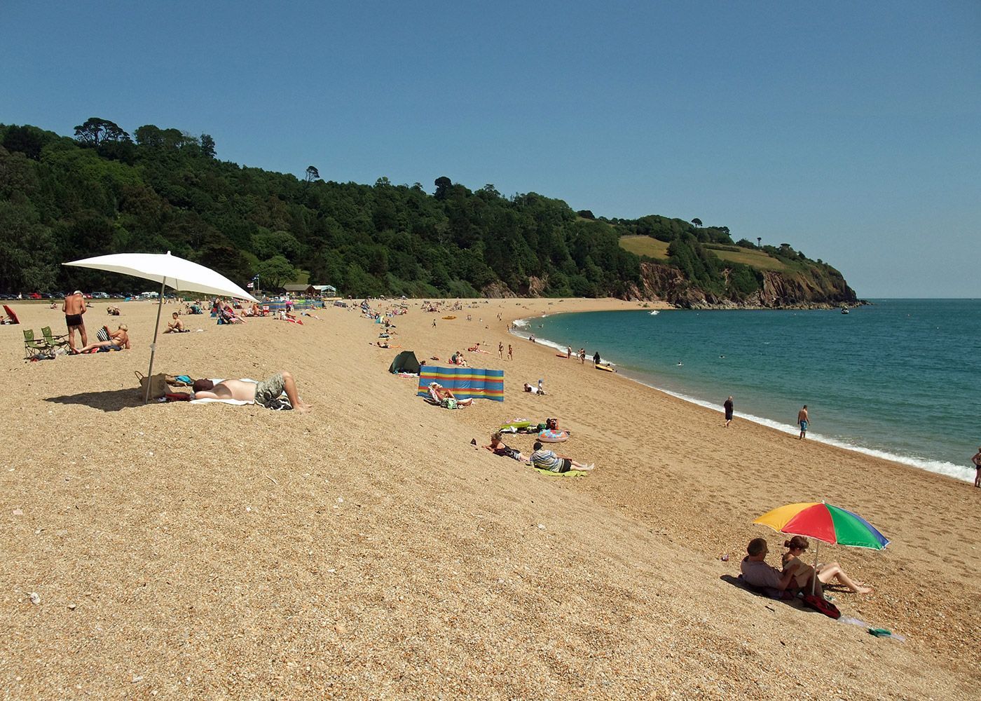 A beach with a lot of people and umbrellas