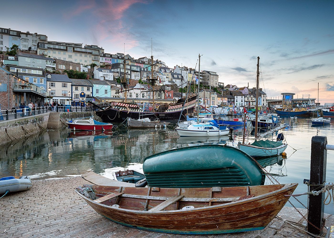 A small wooden boat is docked in a harbor.