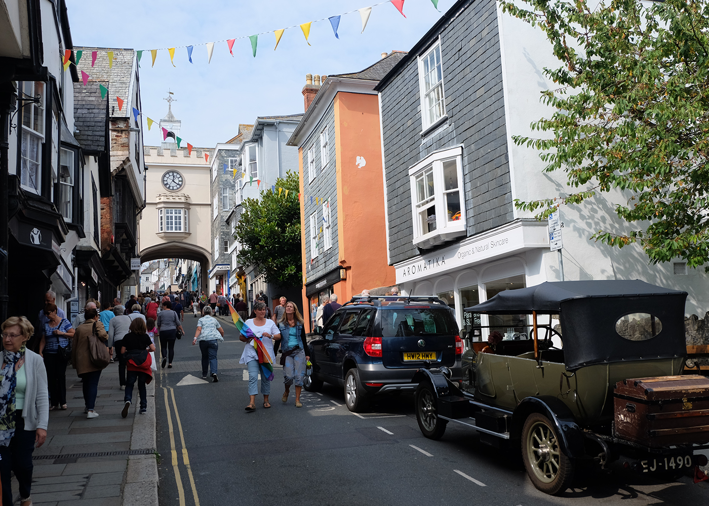 A group of people are walking down a narrow street.