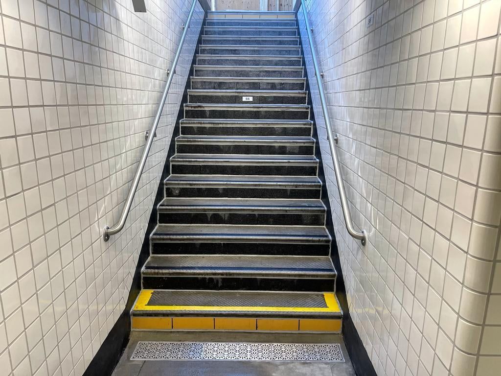 A set of stairs leading up to a subway station.