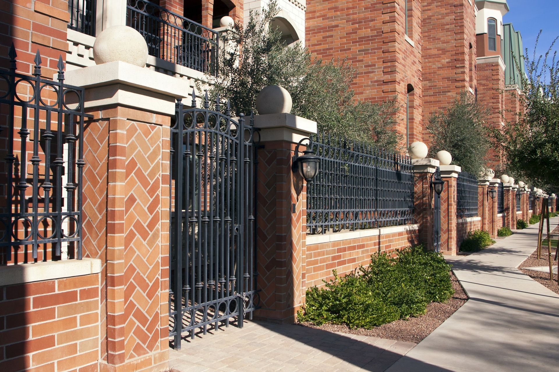 A brick building with a wrought iron gate in front of it