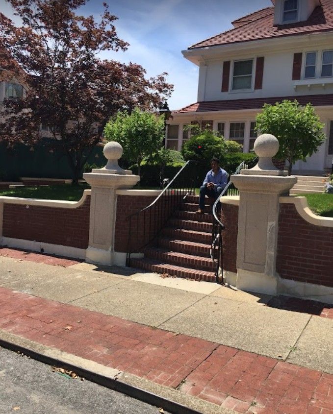 A man sits on the steps of a house