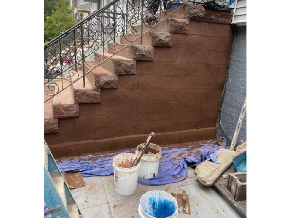 A staircase is being painted with buckets of paint and brushes.