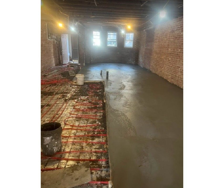 A room with a concrete floor and a brick wall.