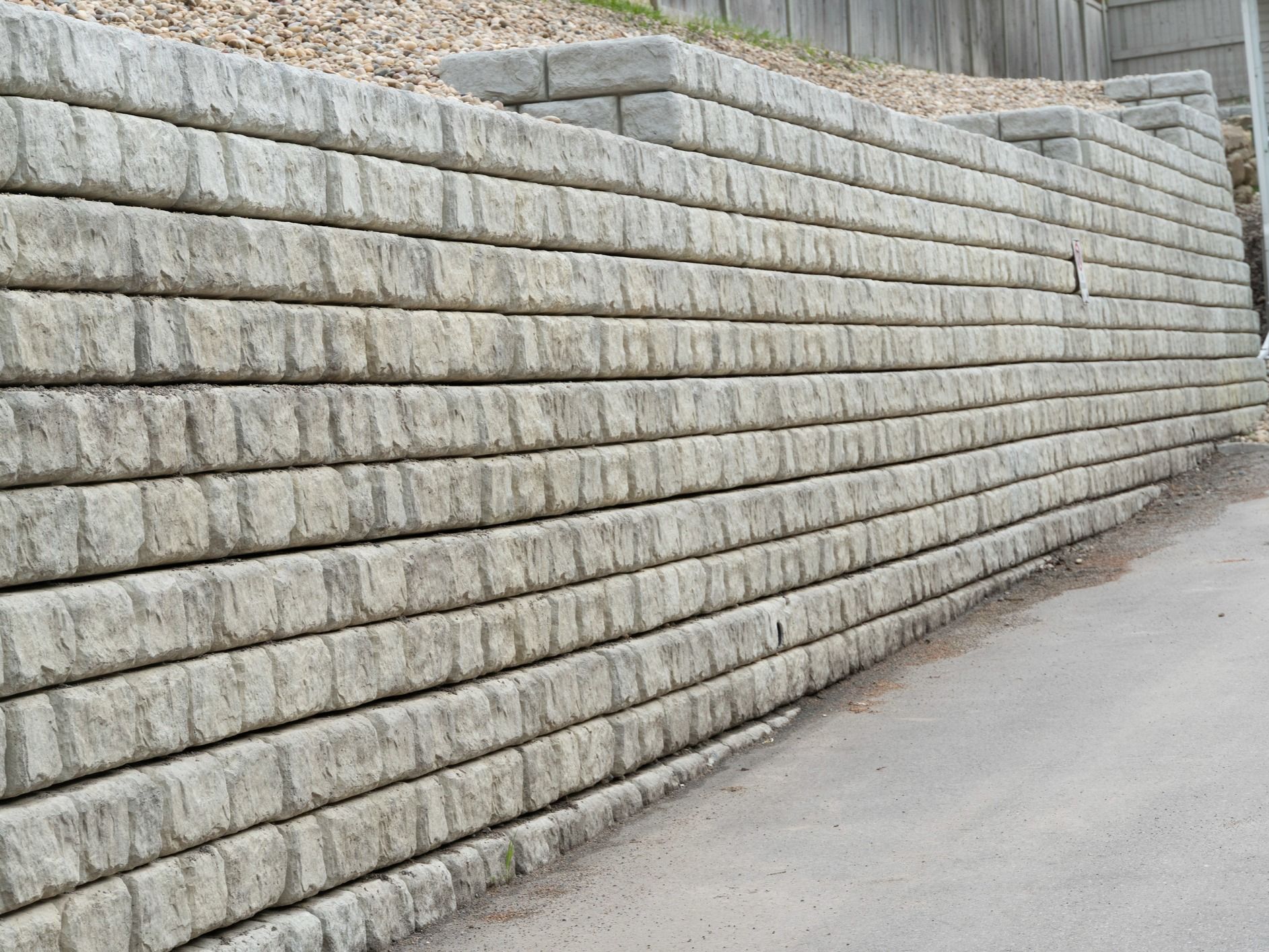 A large concrete wall is sitting on the side of a road.