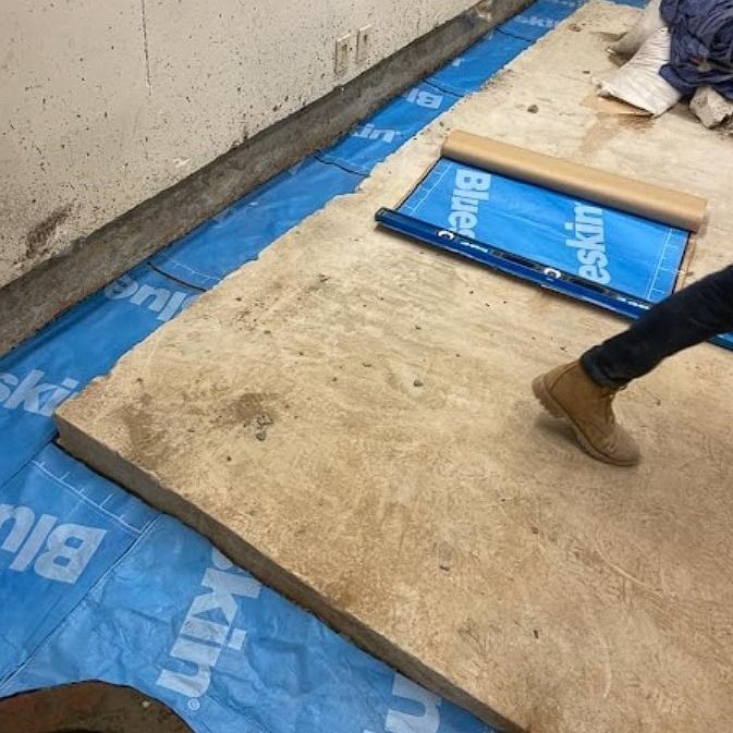 A person is walking on a blue tarp that says blue on it