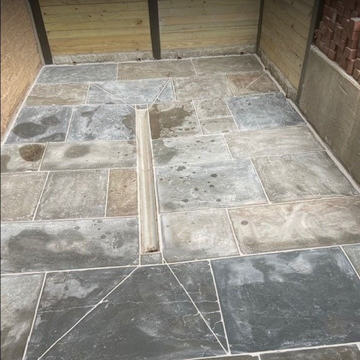 A tiled floor with a wooden fence in the background.