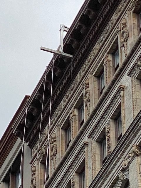 Ornate stone building facade viewed from below against a cloudy sky