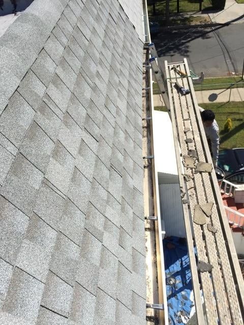A man is working on the roof of a house