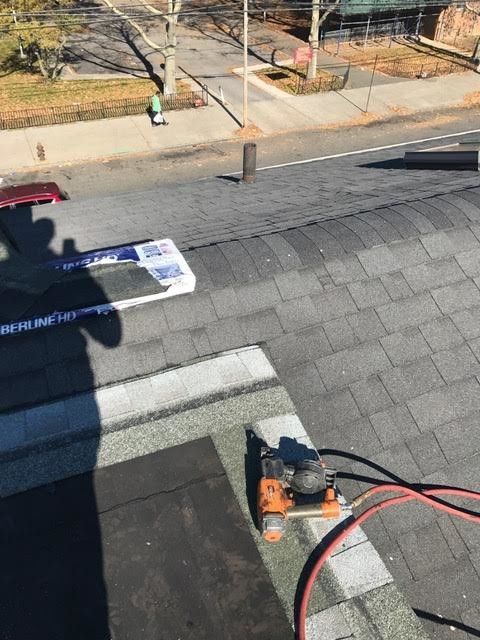 A person is working on a roof with a tool.