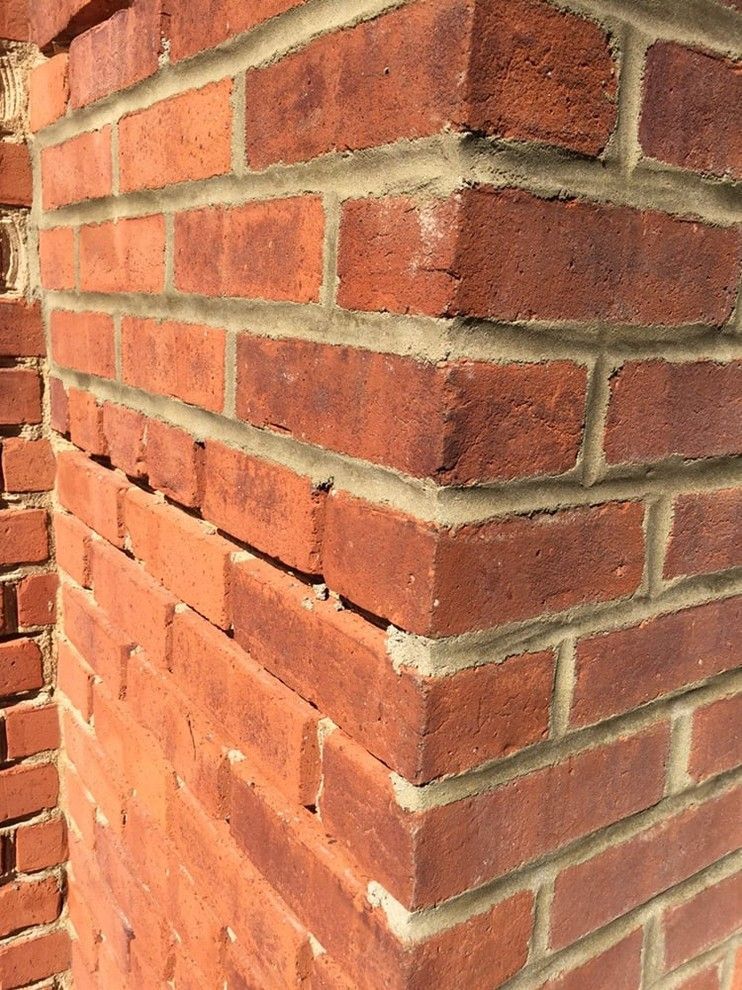 A close up of a red brick chimney on a building.