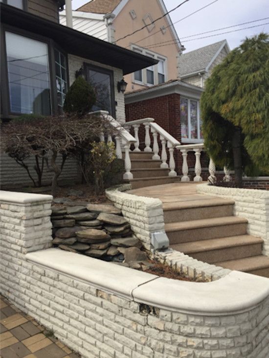 A brick wall with stairs leading up to a house