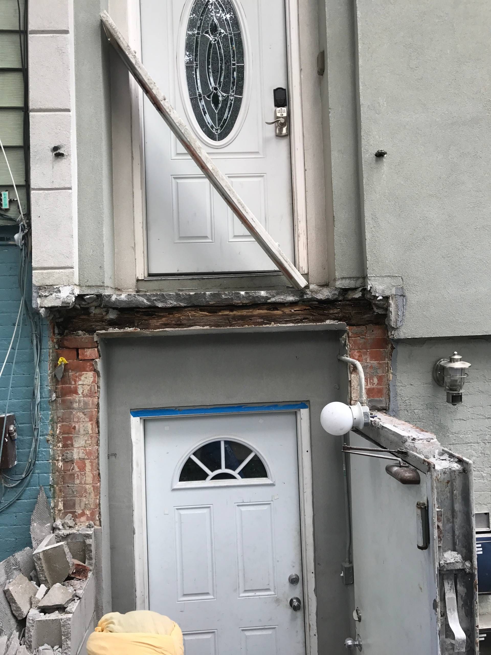 A white door is being installed on the side of a building