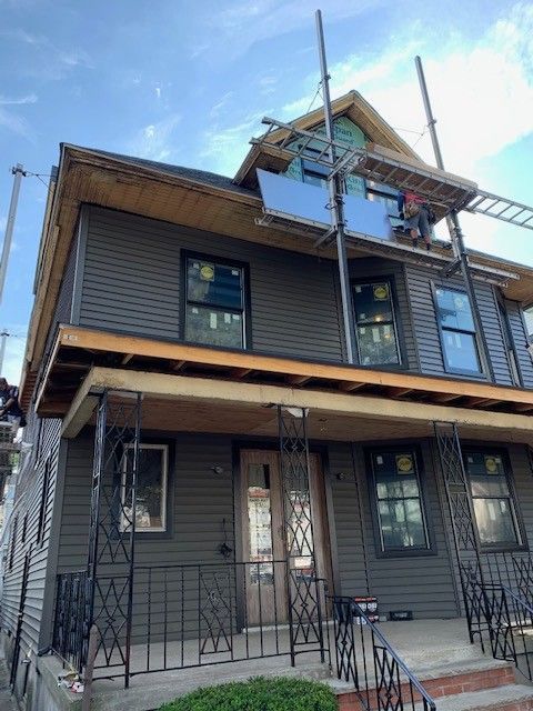 A house is being painted with a scaffolding on top of it.