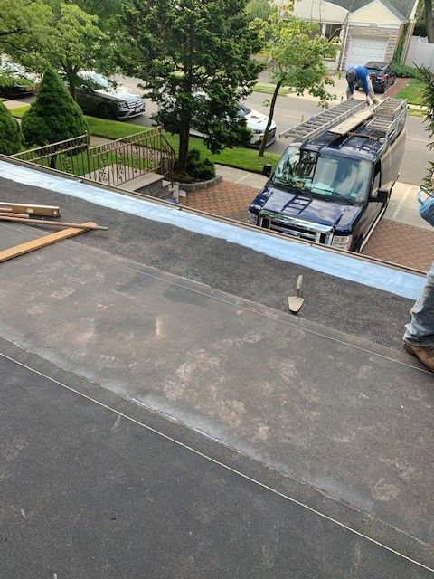 A blue van is parked on the roof of a house.