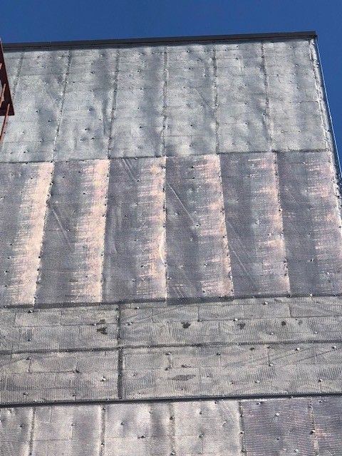 A close up of a building 's roof with a blue sky in the background.