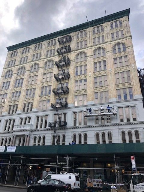 A large building with a lot of windows is being painted.
