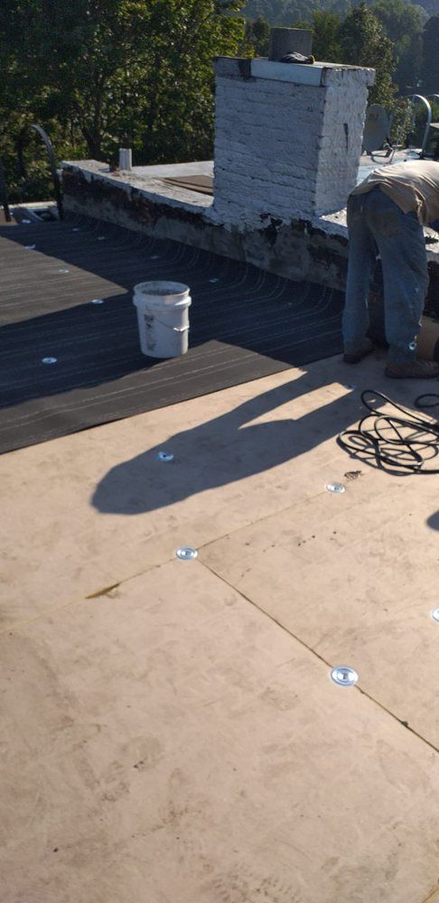 A man is working on the roof of a building.
