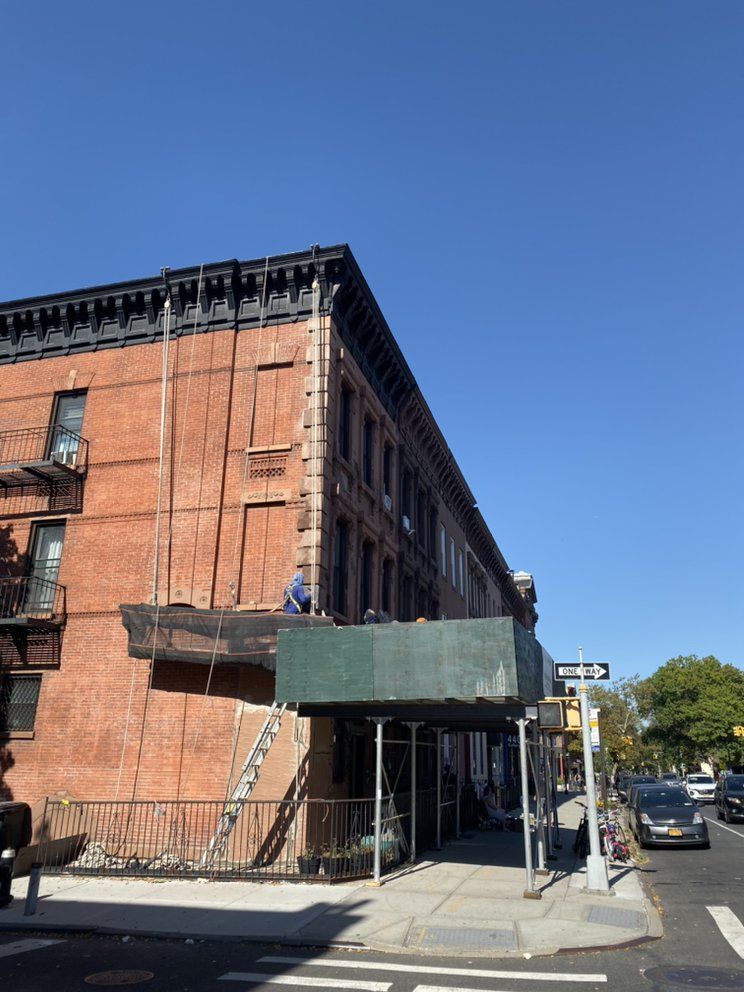 A brick building with a green awning on the side of it