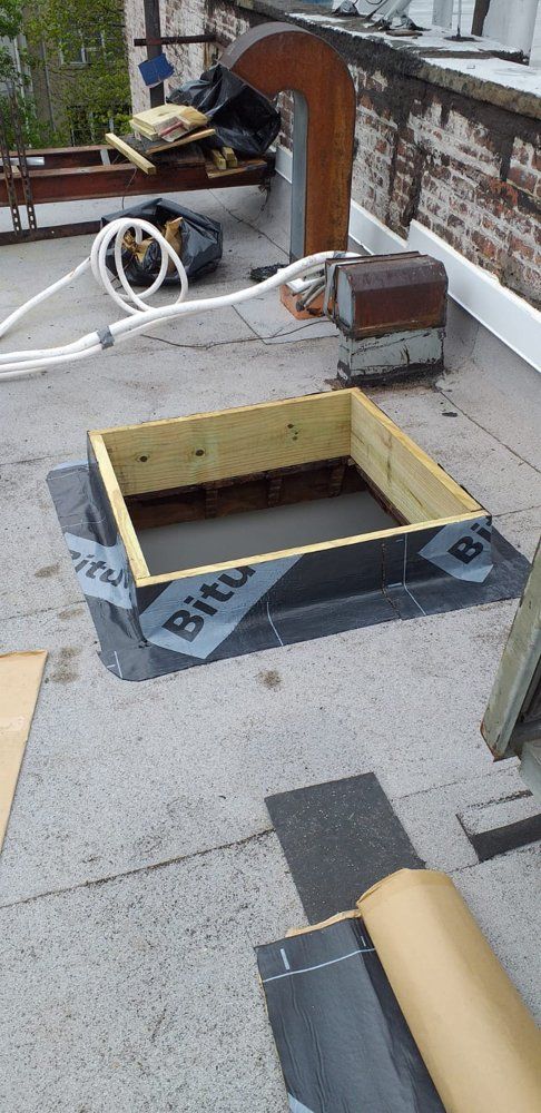 A wooden box is sitting on top of a concrete roof.