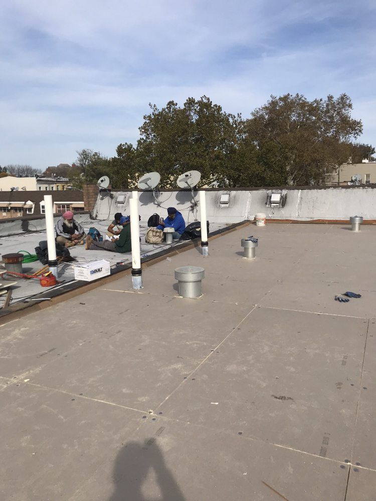 A group of people are working on the roof of a building.