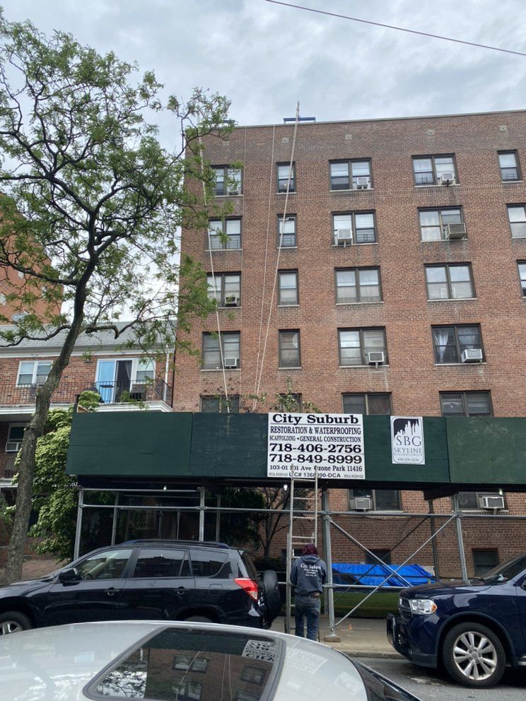 A large brick building with cars parked in front of it.