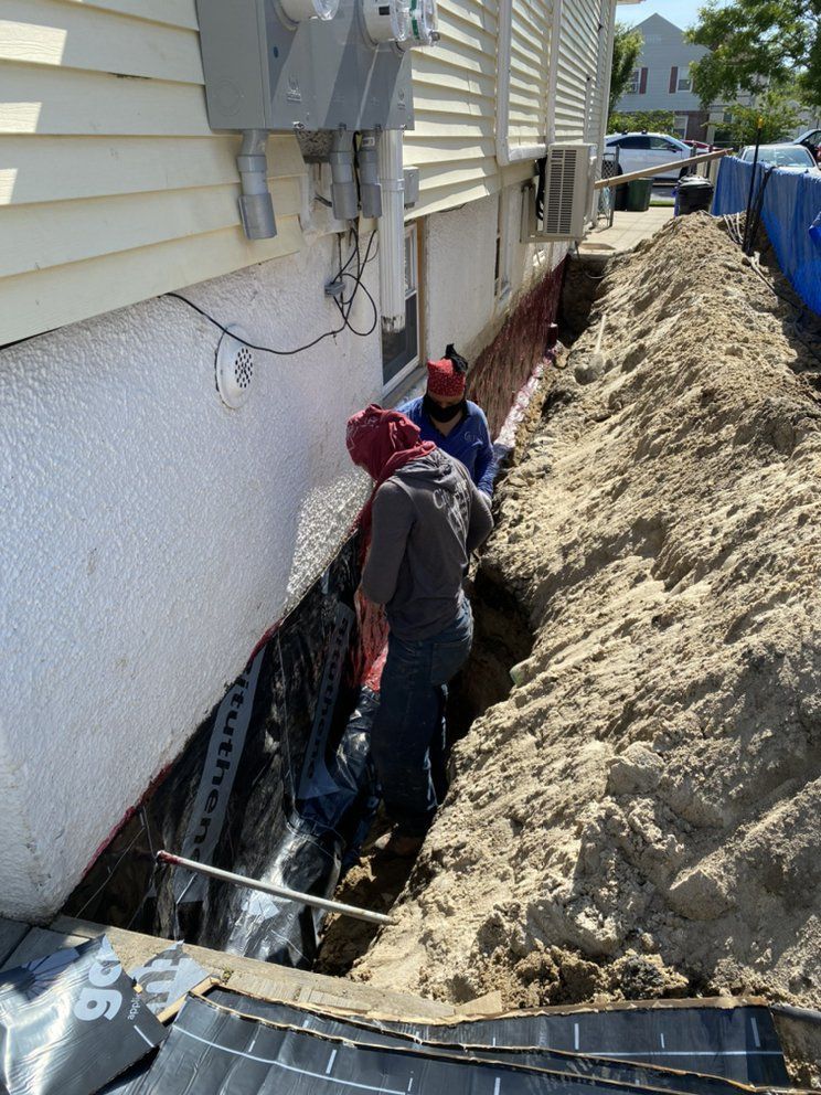 A group of men are digging a hole in the side of a house.