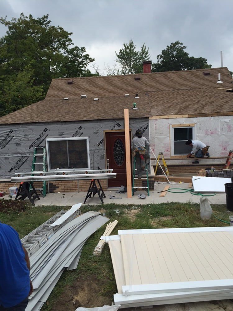 A man is standing in front of a house that is being remodeled.
