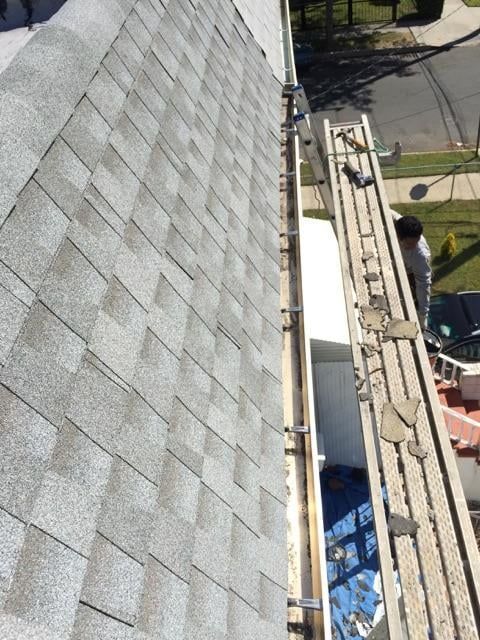 A man is working on the roof of a house