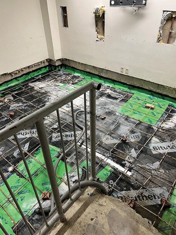 A staircase leading up to a room with a concrete floor.