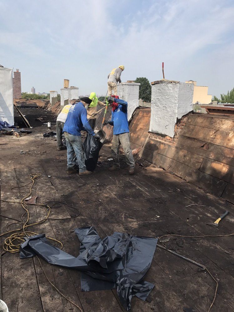 A group of construction workers are working on a roof.