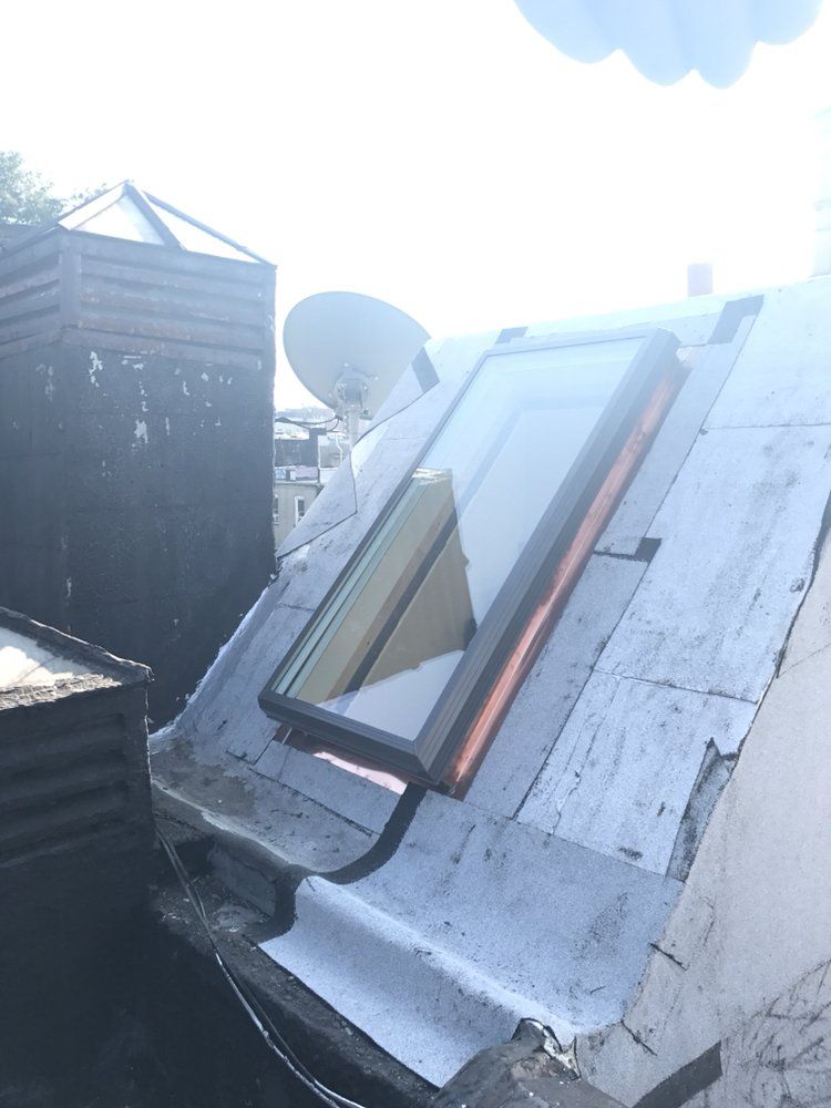 A roof with a window and a satellite dish on it