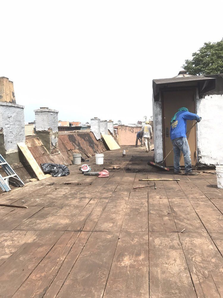 A man is standing on top of a wooden roof.