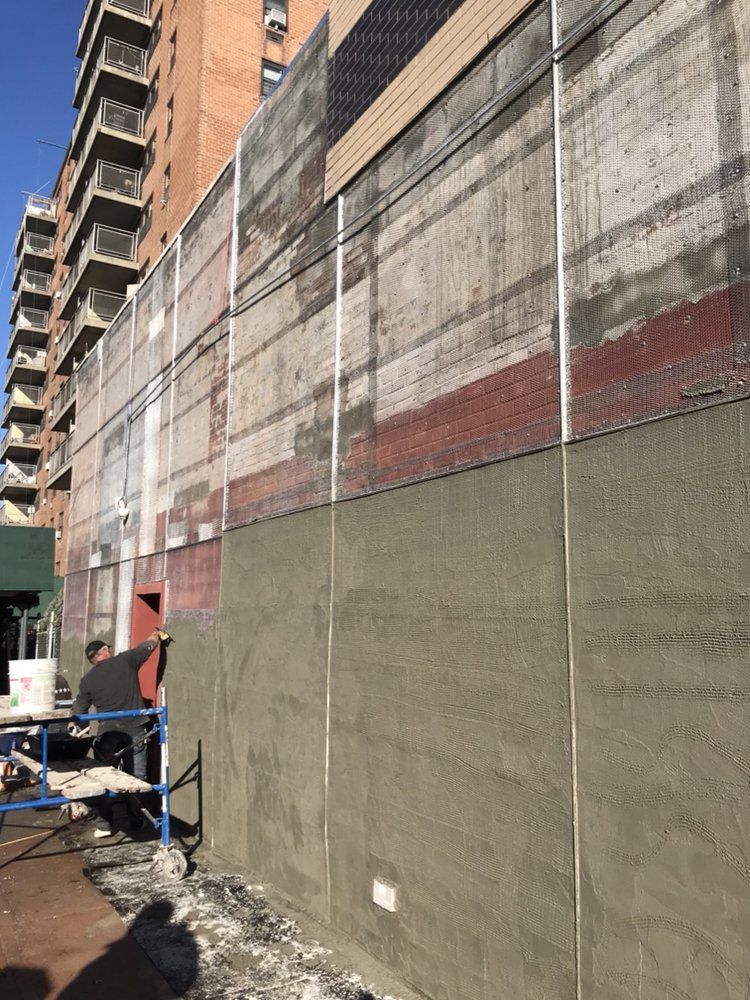 A man is working on a wall of a building.